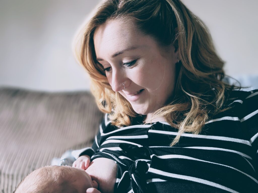 Mum breastfeeding baby smiling